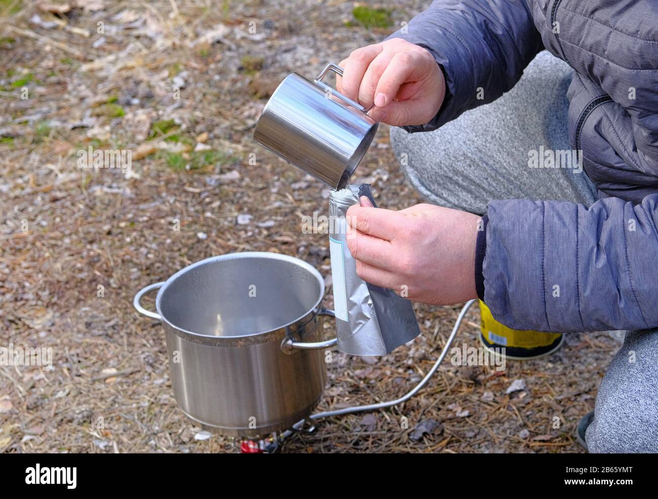 Traveler is eating freeze dried food during camping. Enjoy a tasty food