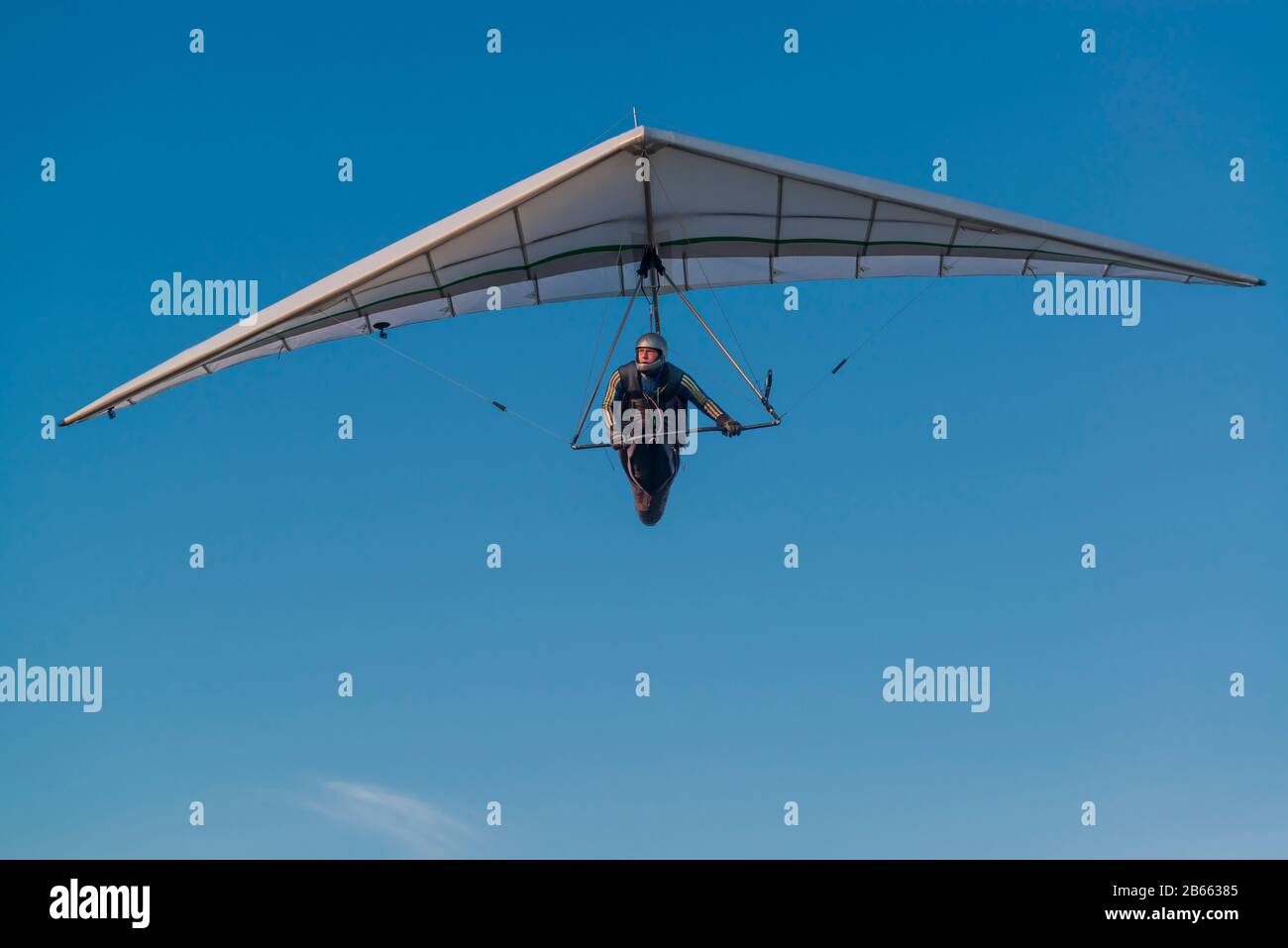Hang glider pilot and his wing. Hangglider wing against bright blue sky. Stock Photo