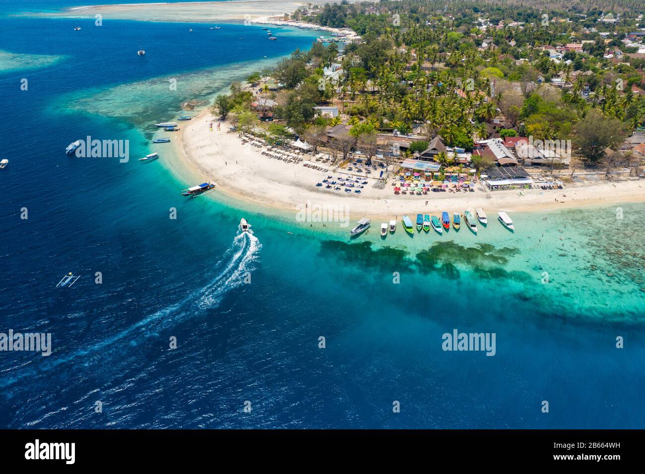 Aerial view of boats moored off a beautiful tropical coral reef and beach on a small island (Gili Air, Indonesia) Stock Photo