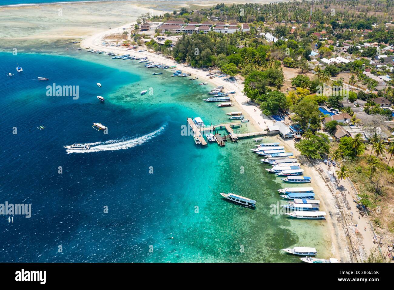 Aerial view of boats moored off a beautiful tropical coral reef and beach on a small island (Gili Air, Indonesia) Stock Photo