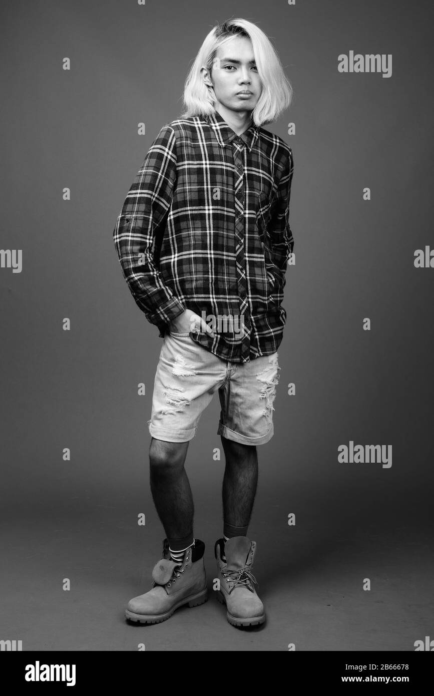 Young Asian man wearing stylish clothes against gray background Stock Photo