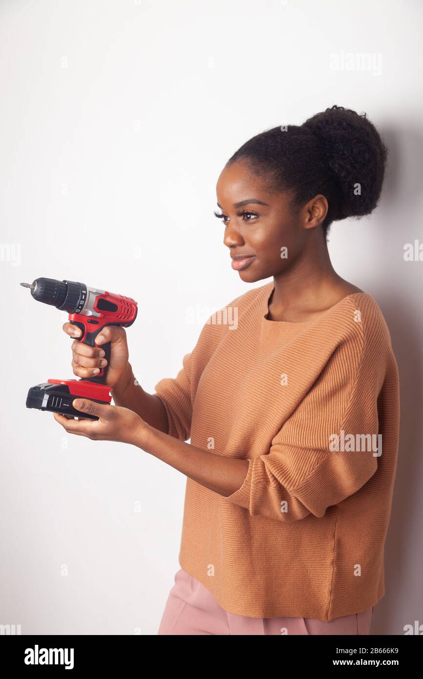 African woman holding cordless drill Stock Photo