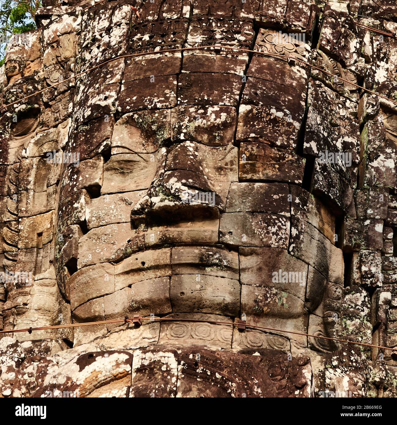 Archeological site ,The South Gate of Angkor Thom leads to Bayon Temple. The city of Angkor Thom, Cambodia was built in the late 12th/early 13th century by the Mahayana Buddhist King Jayavarman VII.It is full of these enigmatic faces, often facing in all four cardinal directions. Are these the face of the God-King or the Buddha? Stock Photo