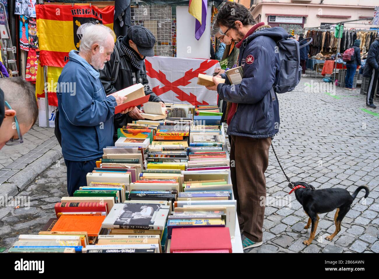 Bargain hunters browsing books in the Rastro flea market around the Plaza de Cascorro between La Latina and Embajadores,  Madrid, Spain. Stock Photo