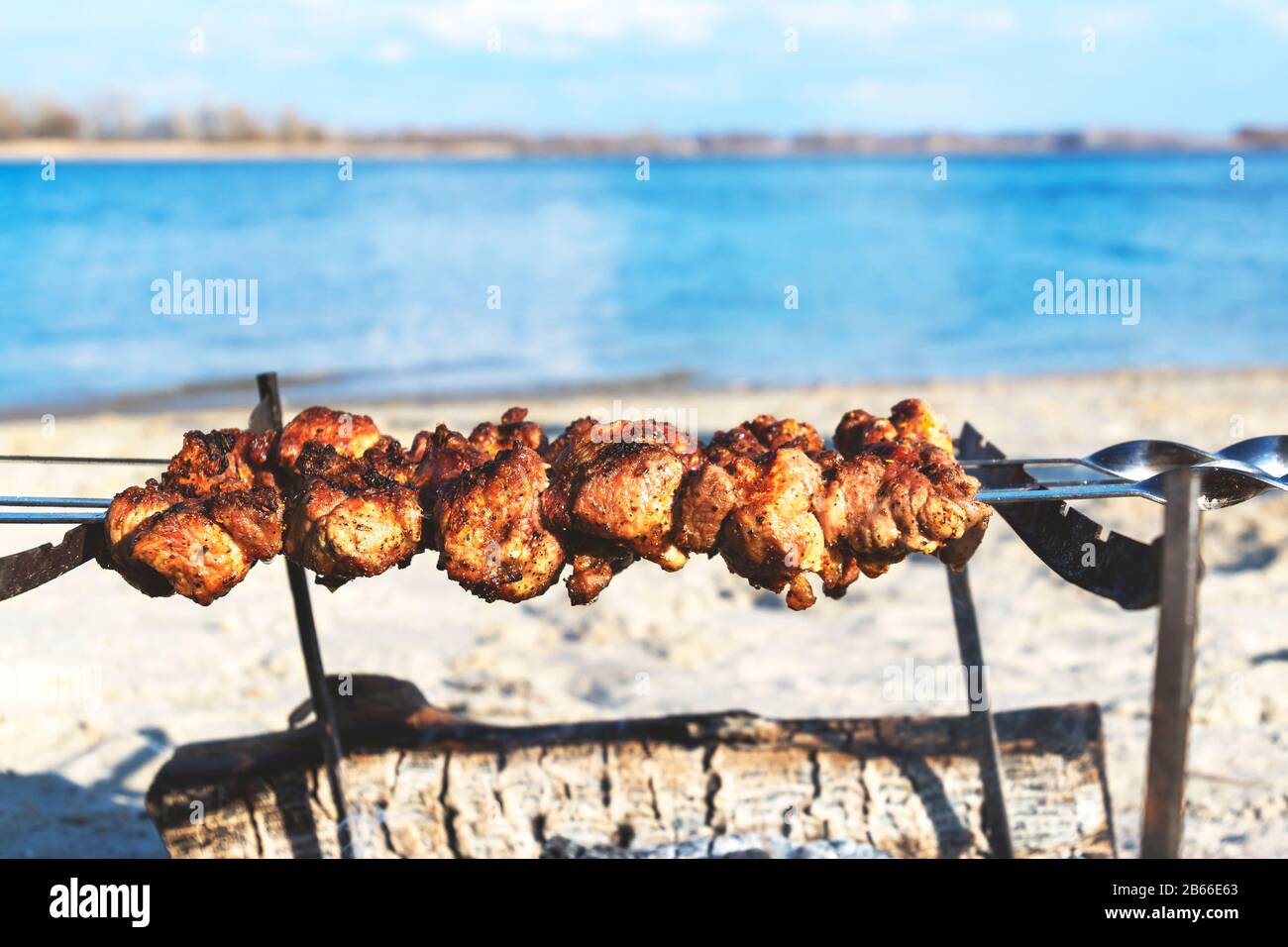 Cooking BBQ meat on beach. Food, summer, beach and leisure concept - grill  barbecue on summer beach Stock Photo - Alamy