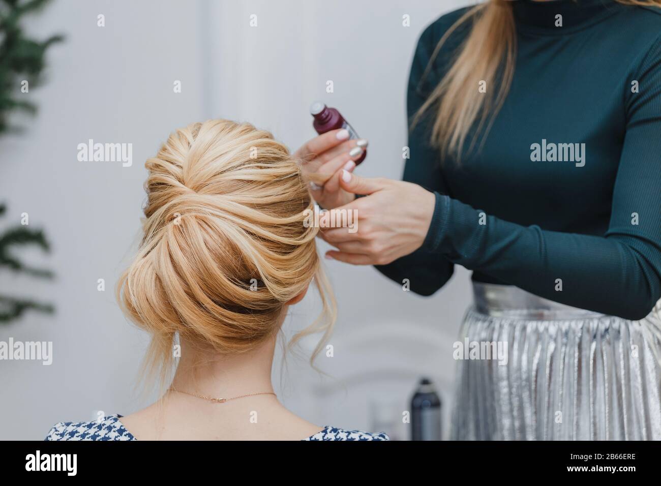 closeup of professional hairdresser hands doing beauty hairstyle ala