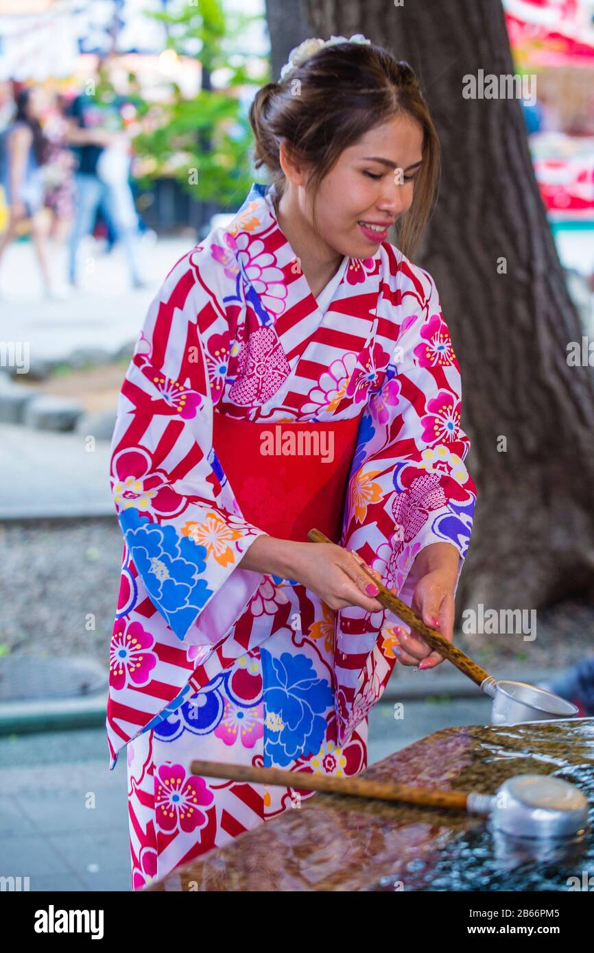 Japanese woman washing hands in a Chozuya in a shrine in Tokyo Japan