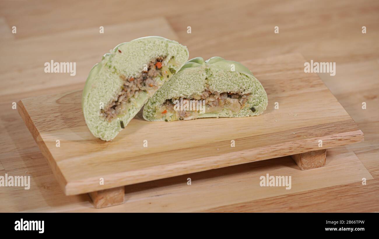 Korean traditional snack, green steamed buns with vegetable fillings on a wooden table Stock Photo
