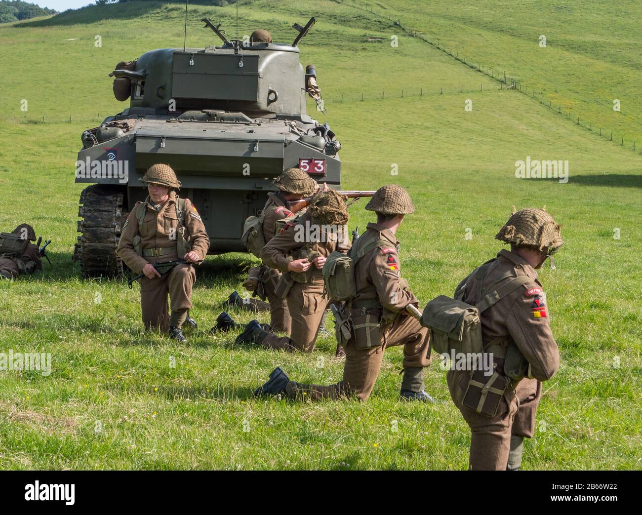 Current soldiers of the Royal Anglian Regiment in WW2 kit performing an infantry platoon attack re-enactment with the support of Sherman tanks. Stock Photo