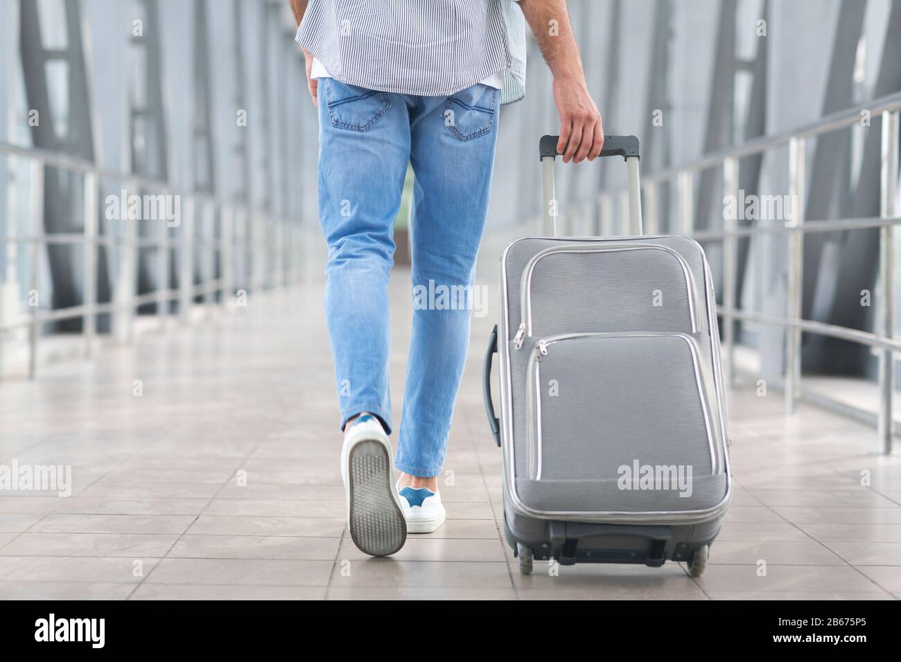 Transit Passenger Concept. Unrecognizable Man Walking With Suitcase In Airport Terminal Stock Photo