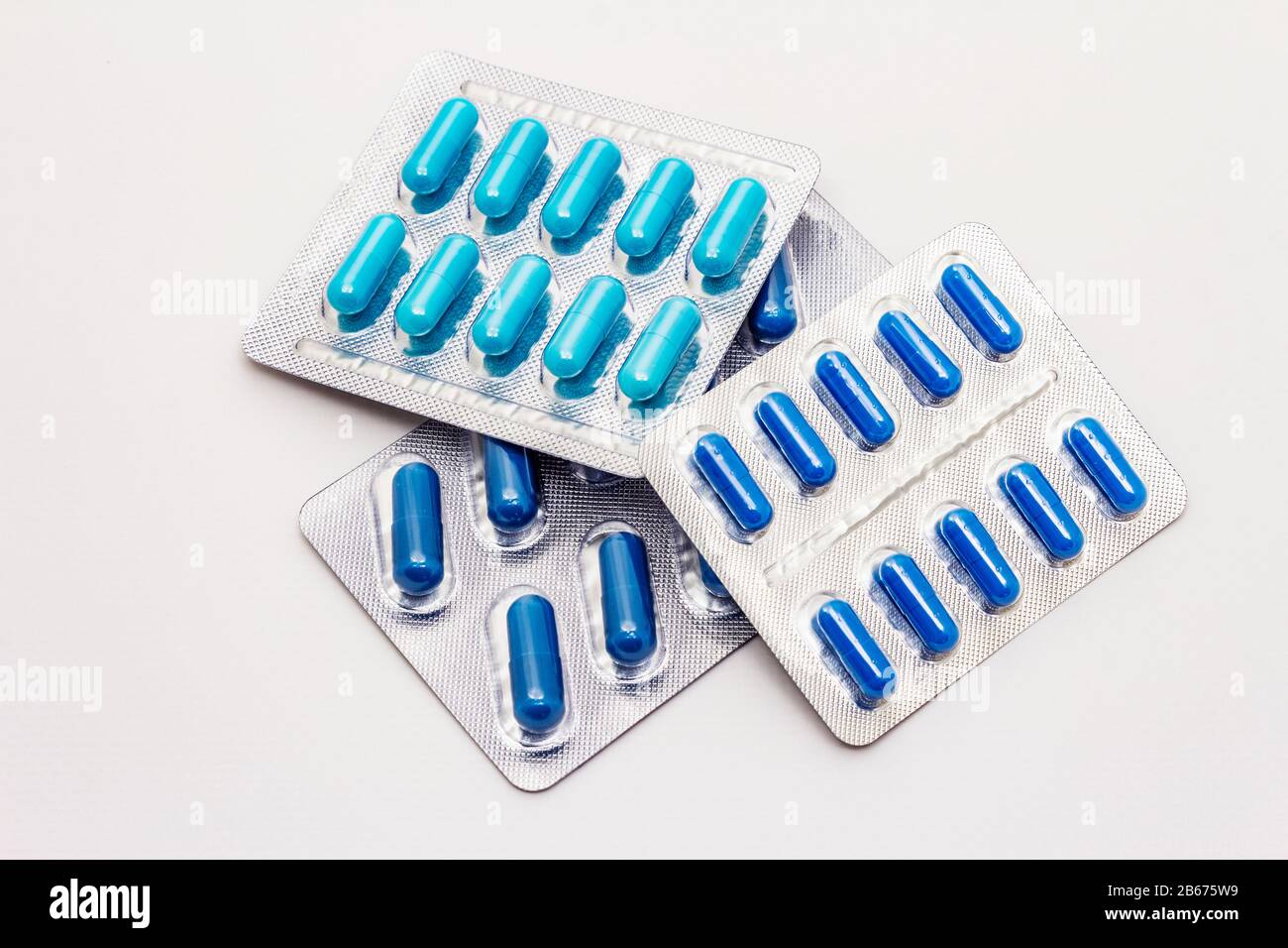 Pharmaceutical tablets, various blue and navy blue capsules in blister pack  isolated on white background. Treatment of various diseases, traditional m  Stock Photo - Alamy