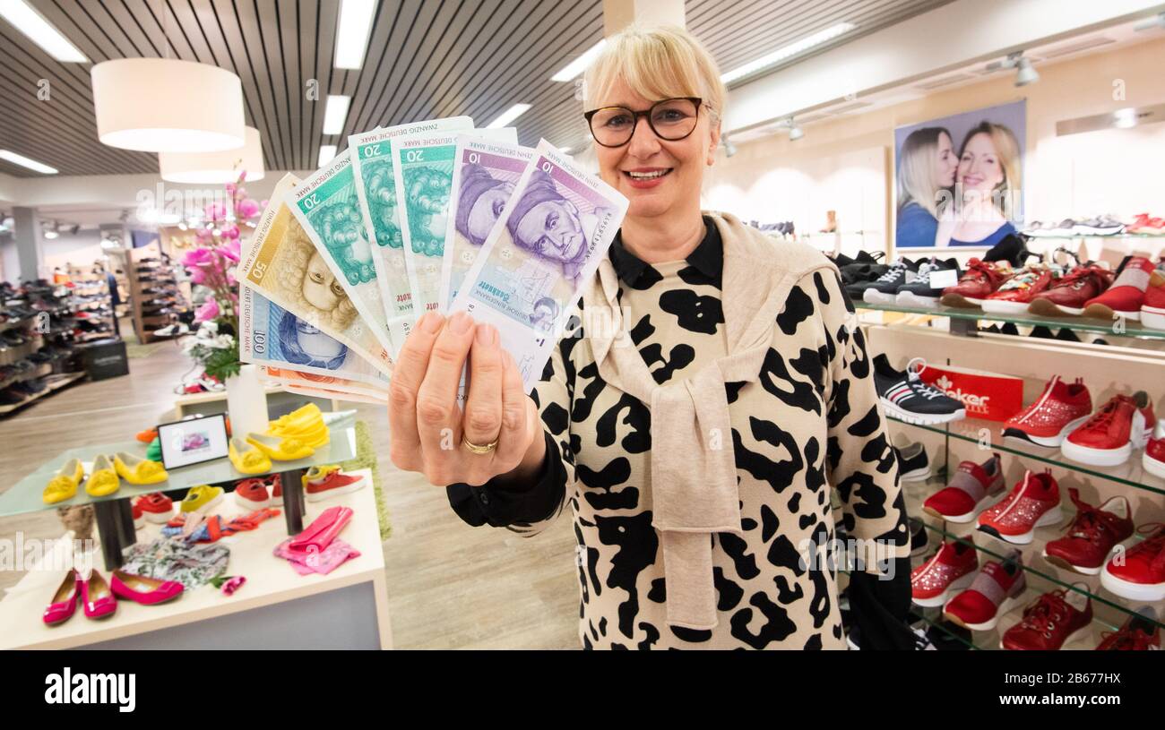 Rinteln, Germany. 10th Mar, 2020. Claudia Döpke from the shoe shop Peters holds D-Mark notes with which customers have bought new shoes. This week, customers of many shops in Rinteln in the Weserbergland region can pay for their purchases not only with euros but also with D-Mark. Credit: Julian Stratenschulte/dpa/Alamy Live News Stock Photo