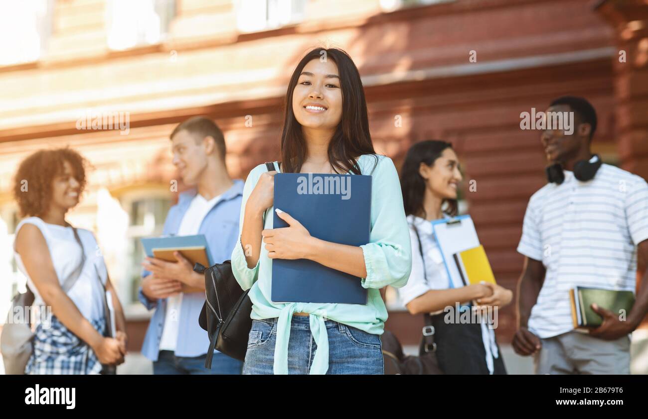 Portrait Of Happy Asian Student Girl Posing Outdoors In Campus Stock Photo