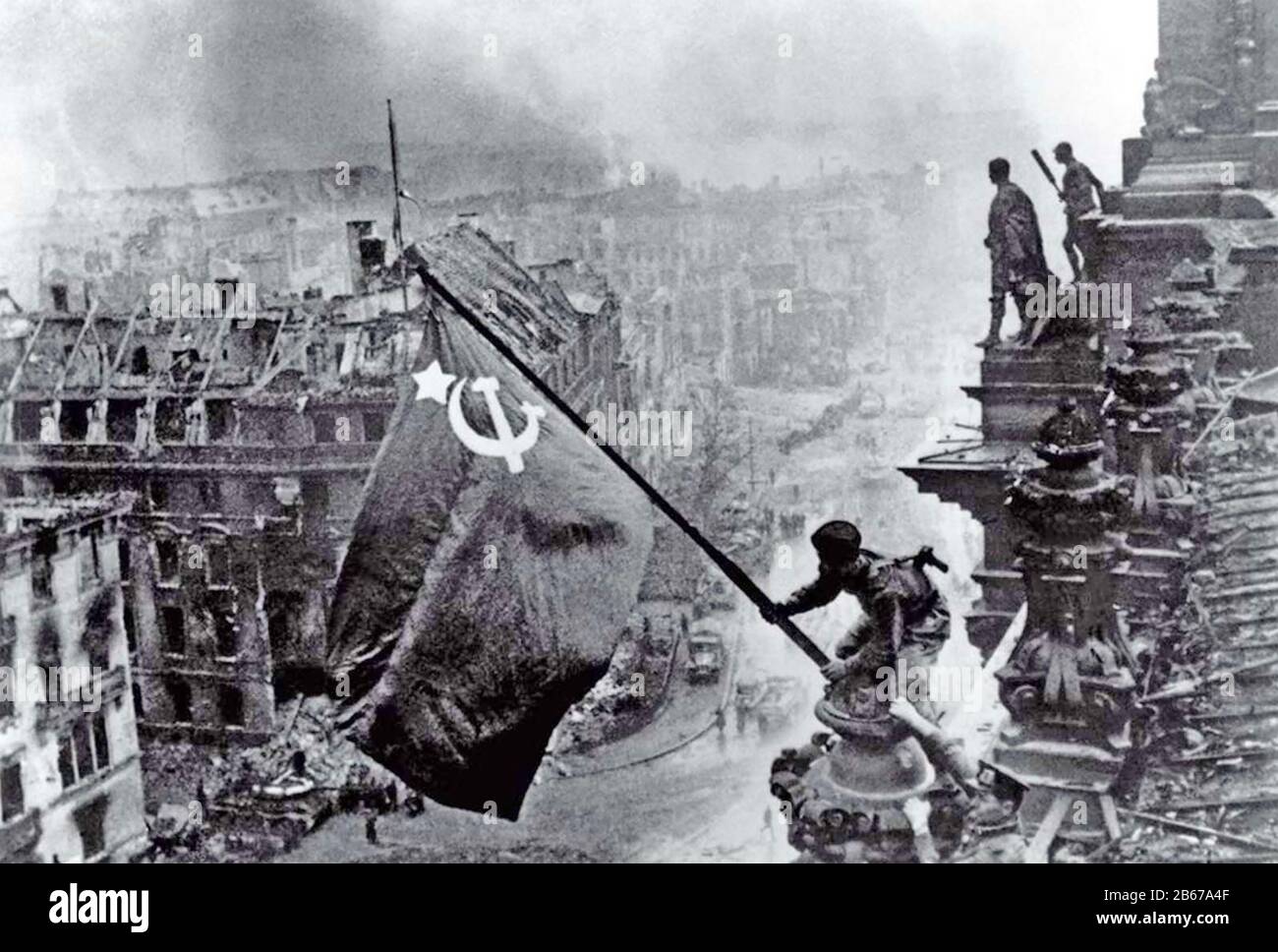 BERLIN 2 May 1945. Red Army soldier flies the Soviet flag from the ruined Reichstag. Photo: Yevgeny Khaldei Stock Photo
