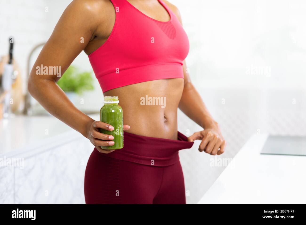 Fit Afro Girl In Oversize Pants Holding Detox Smoothie Stock Photo - Alamy
