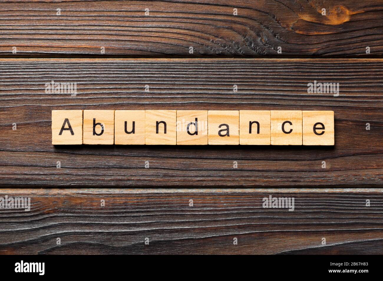 Abundance word written on wood block. Abundance text on wooden table for your desing, Top view concept. Stock Photo