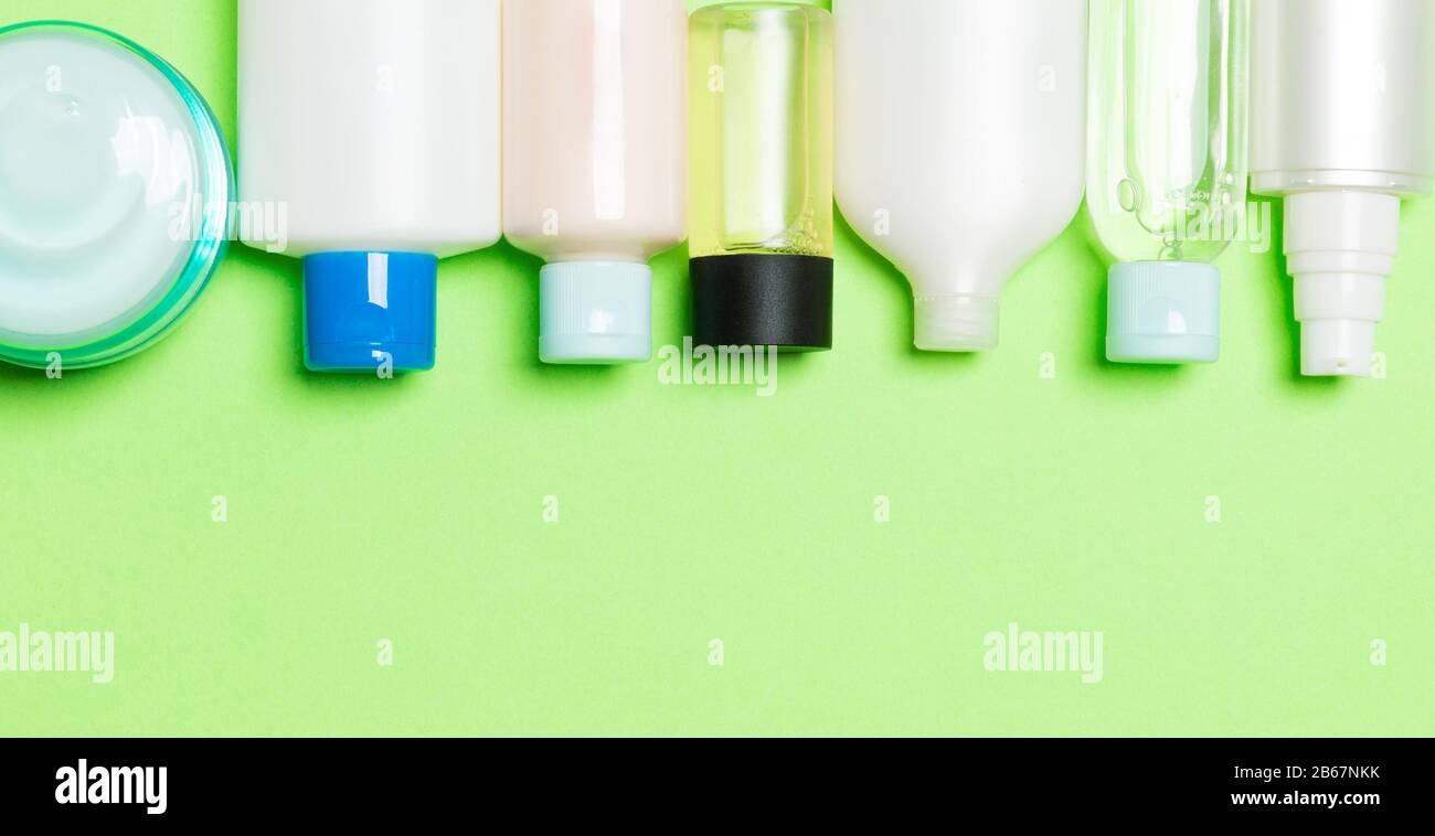 Set of cream and cosmetics bottles and jars on green background ...
