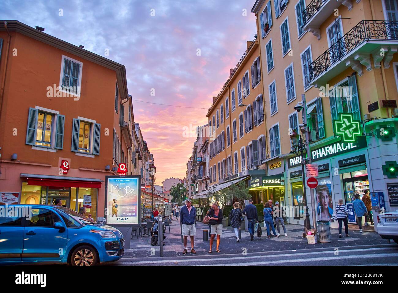 Nice, France - October 5, 2018: City life in an evening in Nice, France. The pedestrian zone with a pharmacy and other shops is idyllically illuminate Stock Photo