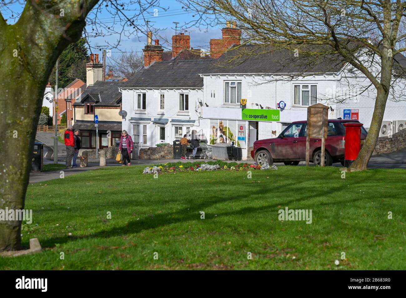 Local people visit the  Co-op store in the village of Pontesbury, Shropshire UK during an unseasonably warm February morning. Stock Photo