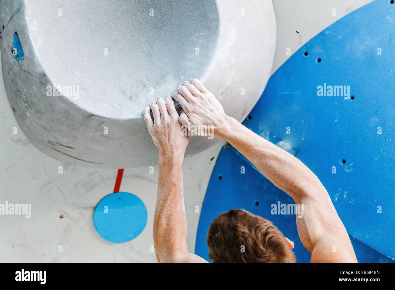 Sport and fitness Man on Extreme Climbing Wall boulder gym Stock Photo