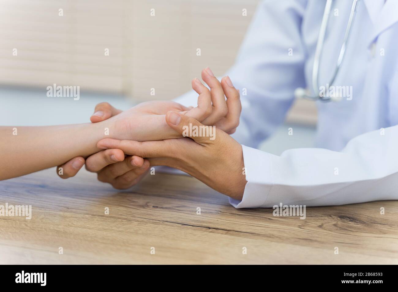 Close up of a doctor holding the patient hands doing basic medical examination and diagnostic. A doctor examines the patient in the hospital. Stock Photo