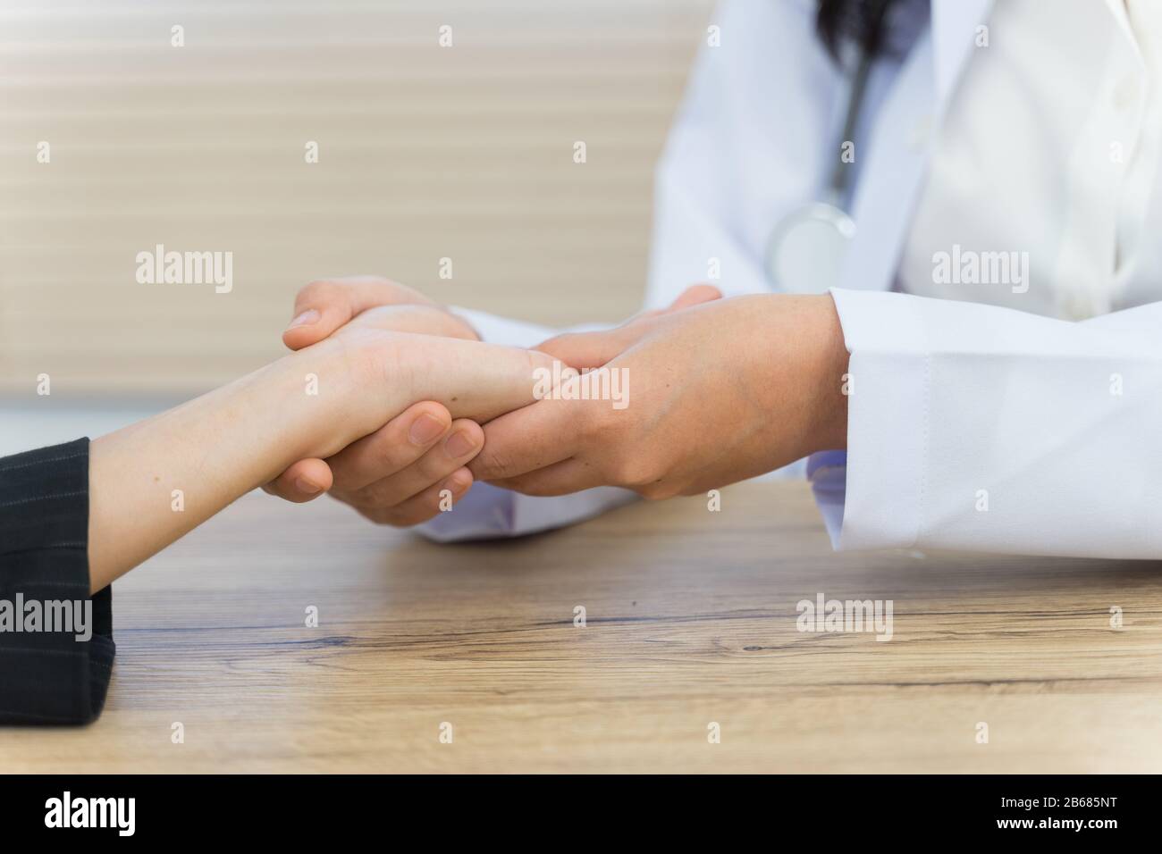 Close up of a doctor holding the patient hands doing basic medical examination and diagnostic. A doctor examines the patient in the hospital. Stock Photo