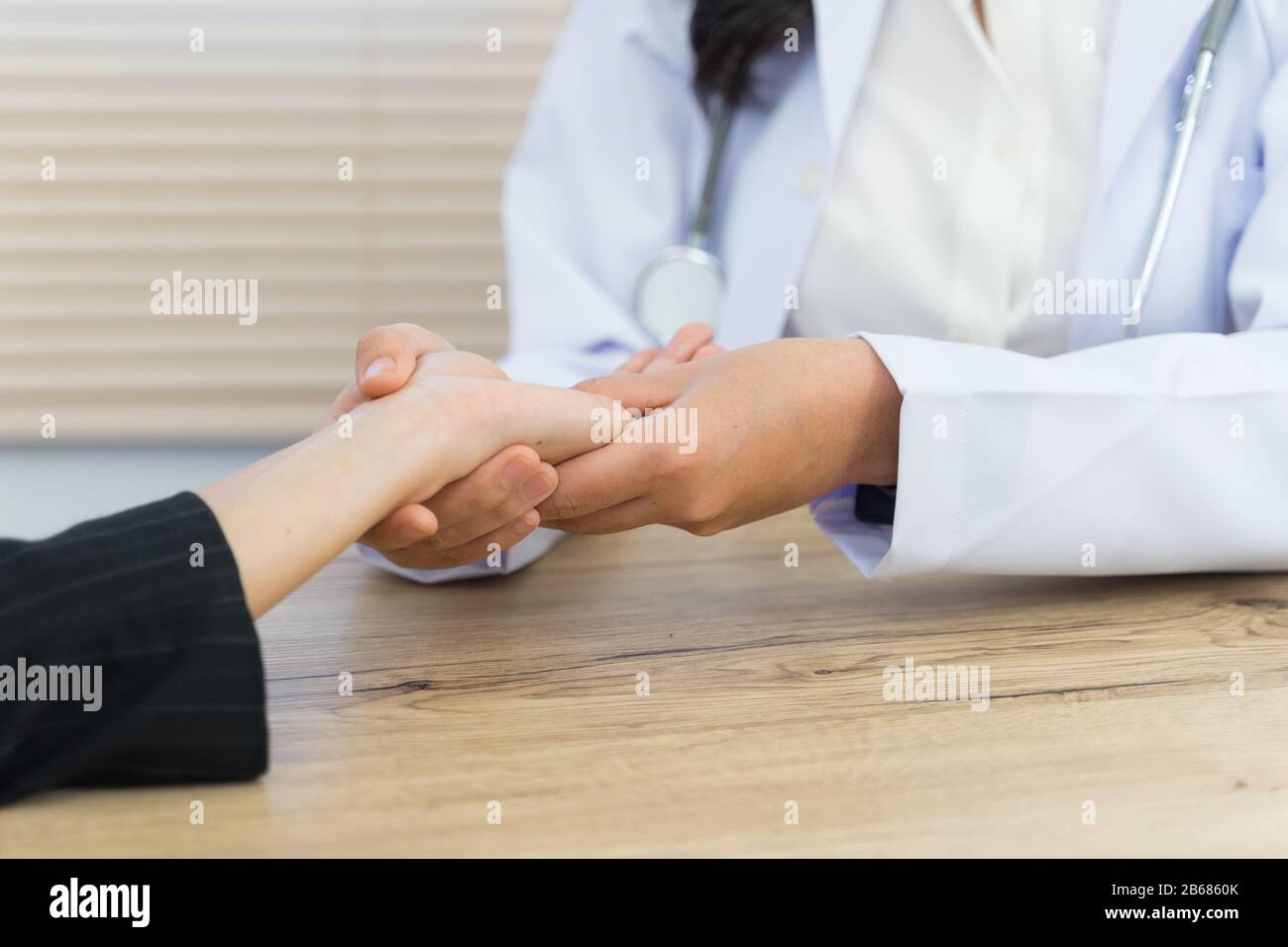 Close up of a doctor holding the patient hands doing basic medical examination and diagnostic. A doctor examines the patient in the hospital. Stock Photo