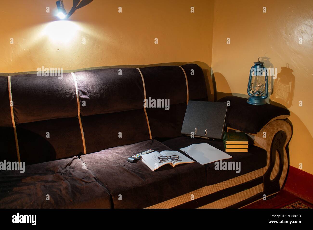 files and books on a couch under a hanging torchlight after a power black out Stock Photo