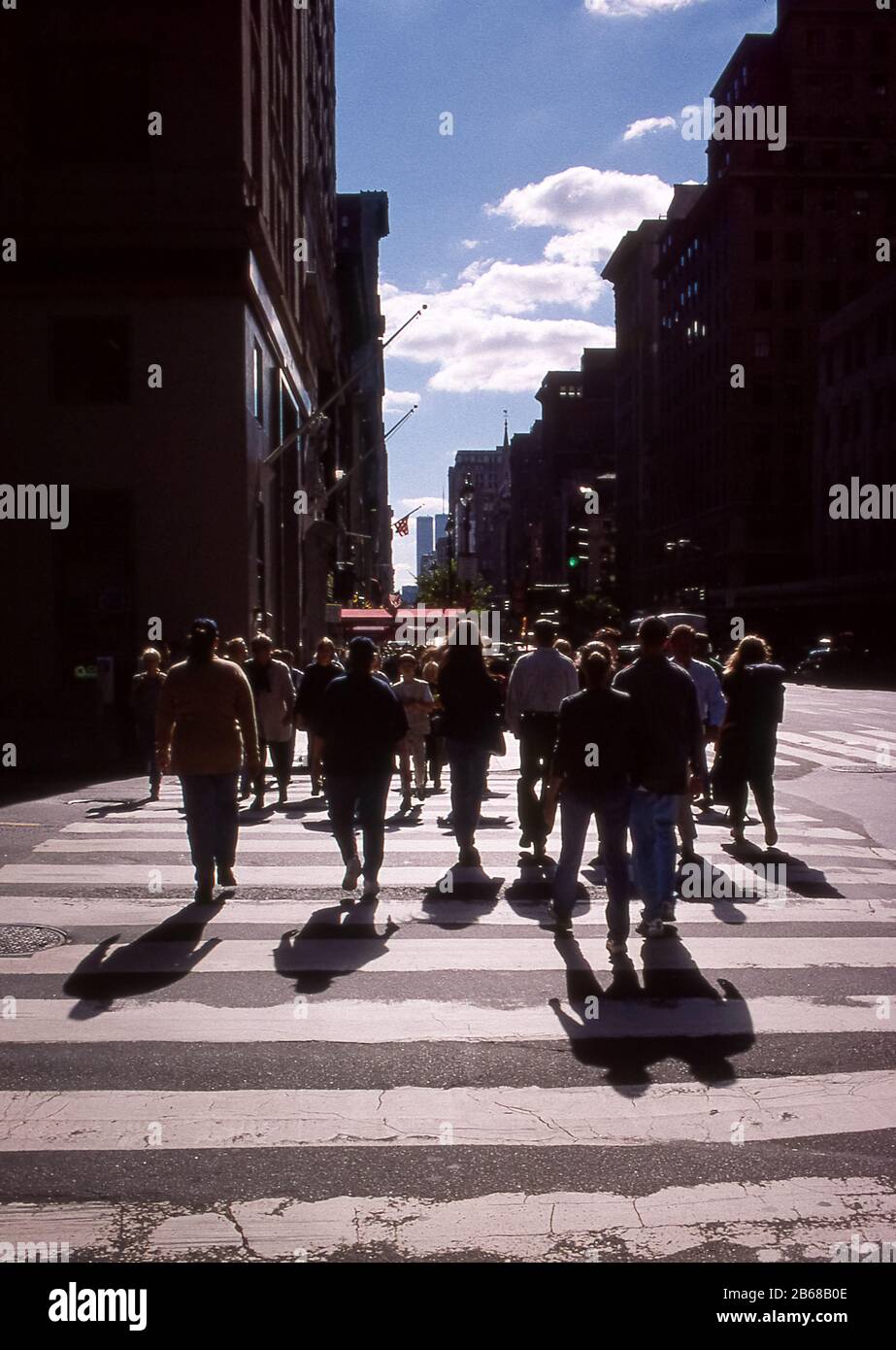 Shadows of people walking across a zebra crossing with the World Trade Center buildings in the distance, New York City, USA, 1998 Stock Photo