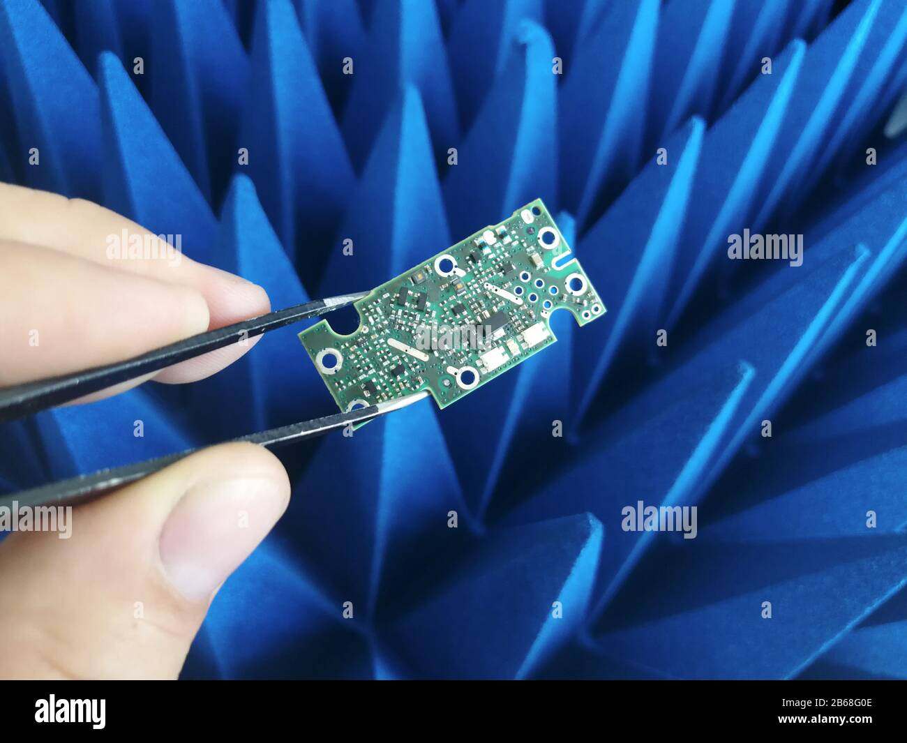 Electronics engineer hand holding printed circuit board in front of ...