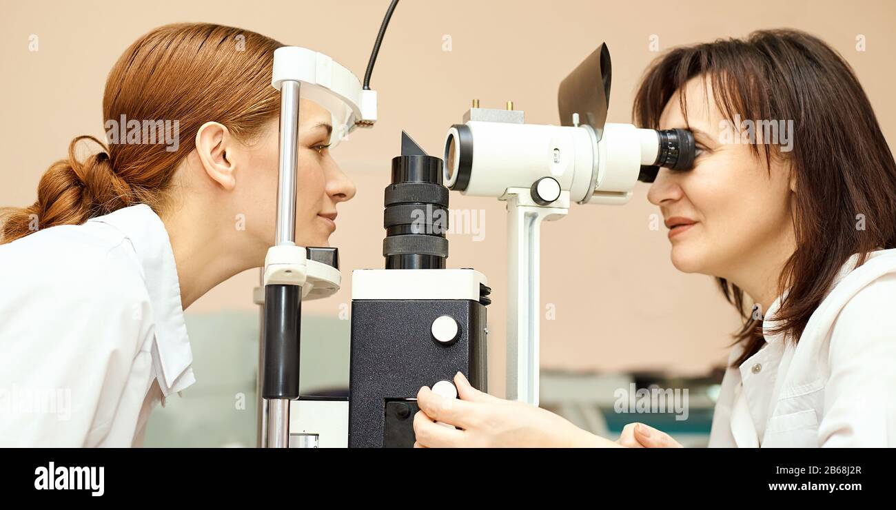 ophthalmologist doctor in exam optician laboratory with female patient. Eye care Stock Photo