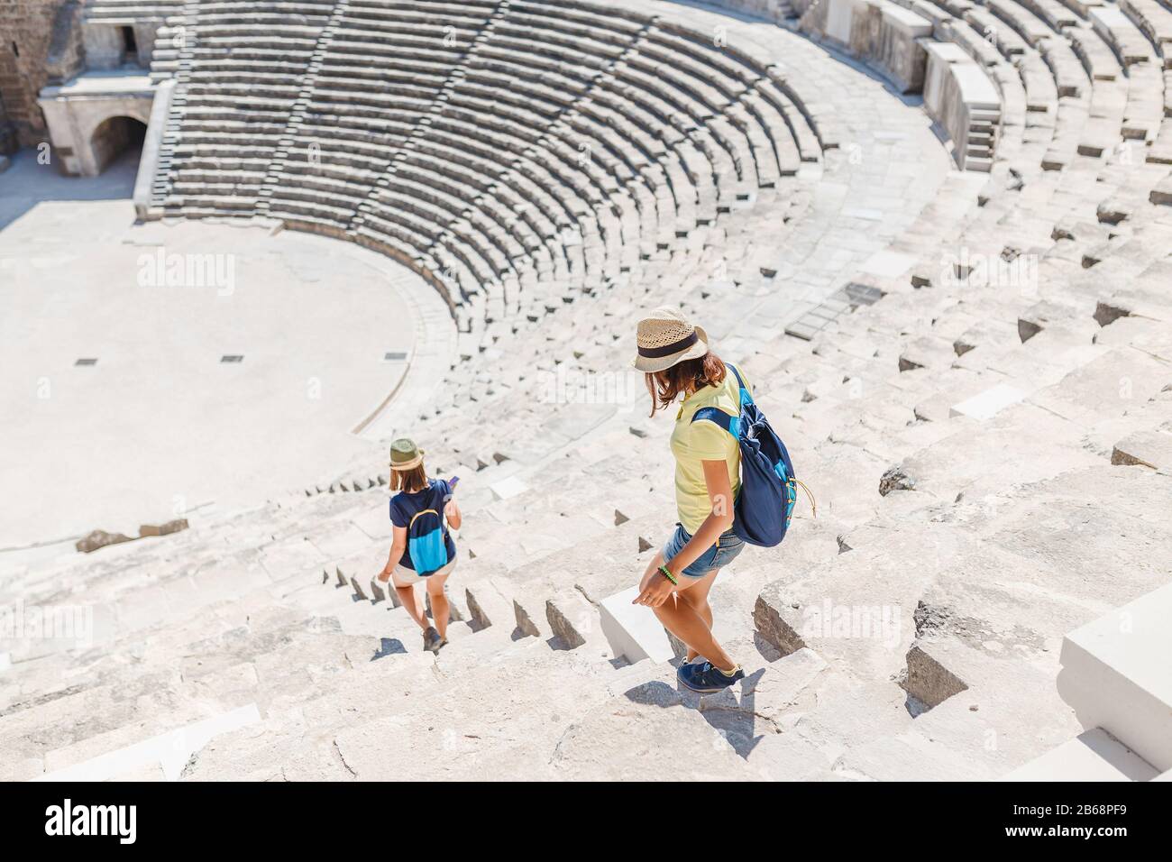 Two young girls student traveler in the ancient amphitheater. archaelolgy travel concept Stock Photo