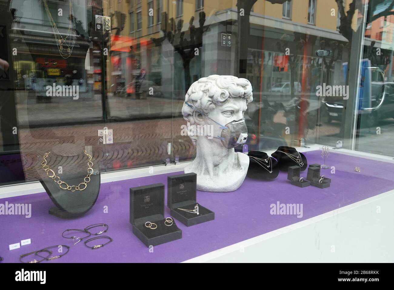 Bellinzona, Switzerland. 10th Mar, 2020. In a shop window of a jewellery  shop there is a replica of the head of Michelangelo's sculpture "David"  with a mouthguard. Bellinzona, the capital of the