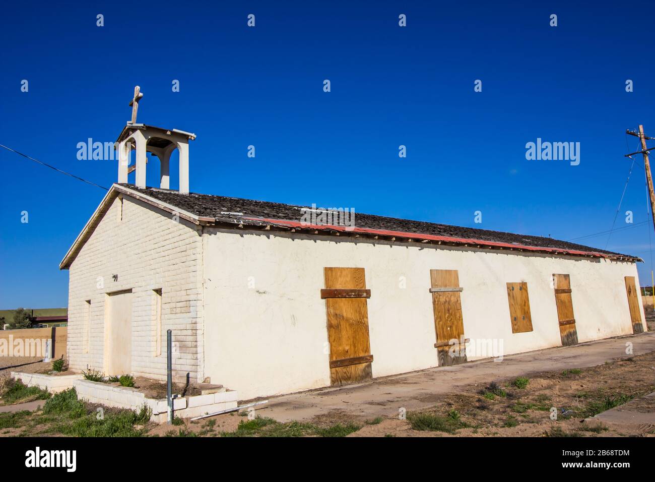 Old Weathered Cross Atop Abandoned Church With Boarded Up Doors Stock Photo