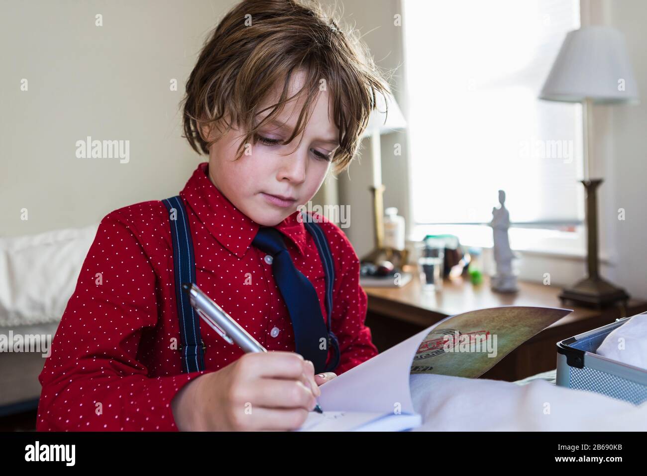 6 year old boy drawing on sketch pad in Stock Photo