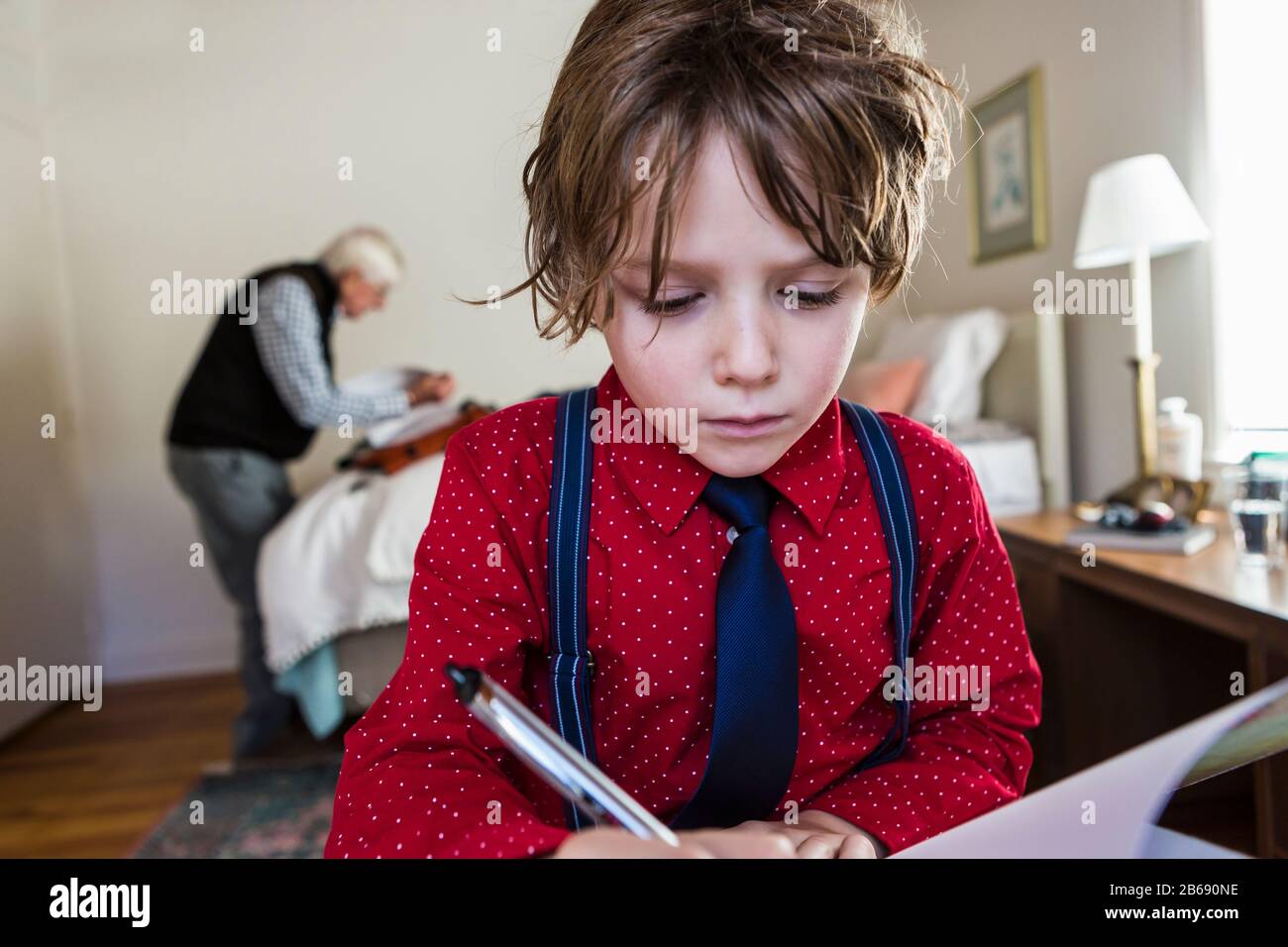 6 year old boy drawing on sketch pad in Stock Photo
