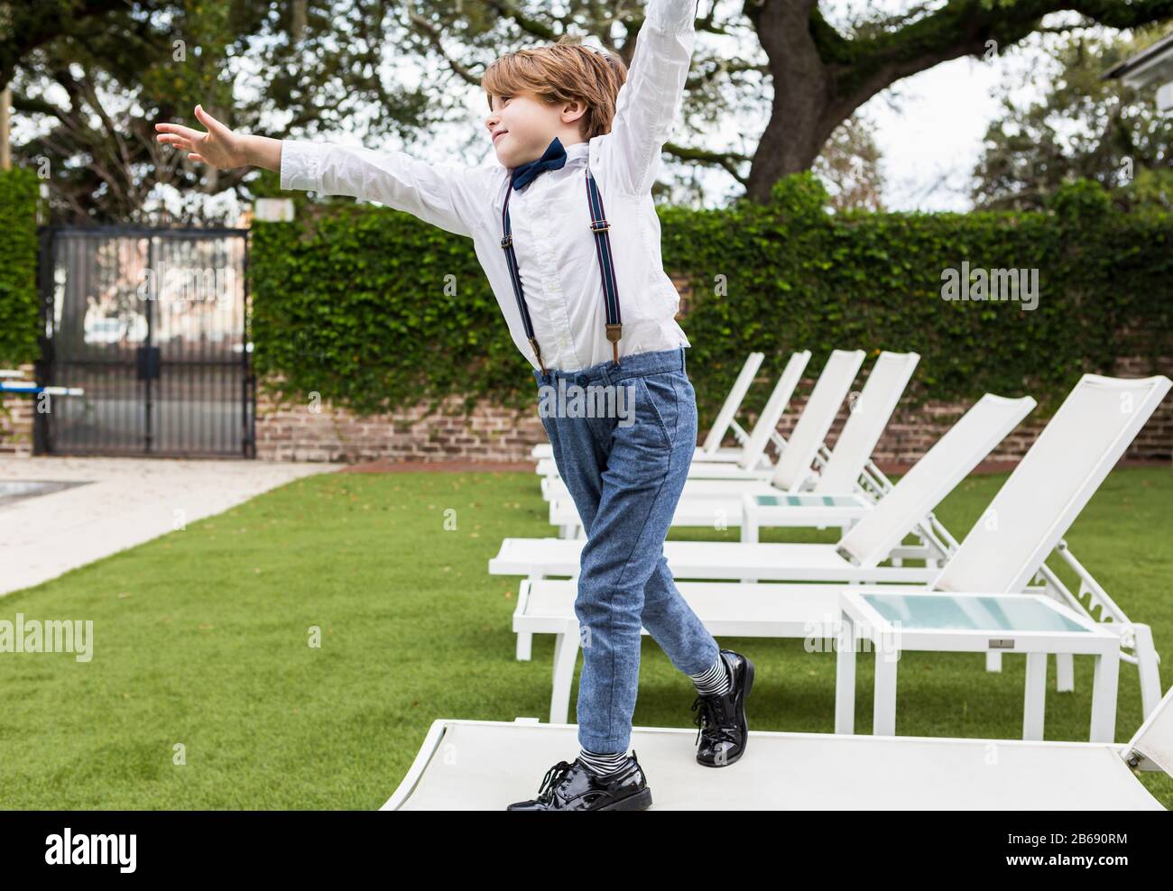 6 year old boy standing on lawn chair Stock Photo