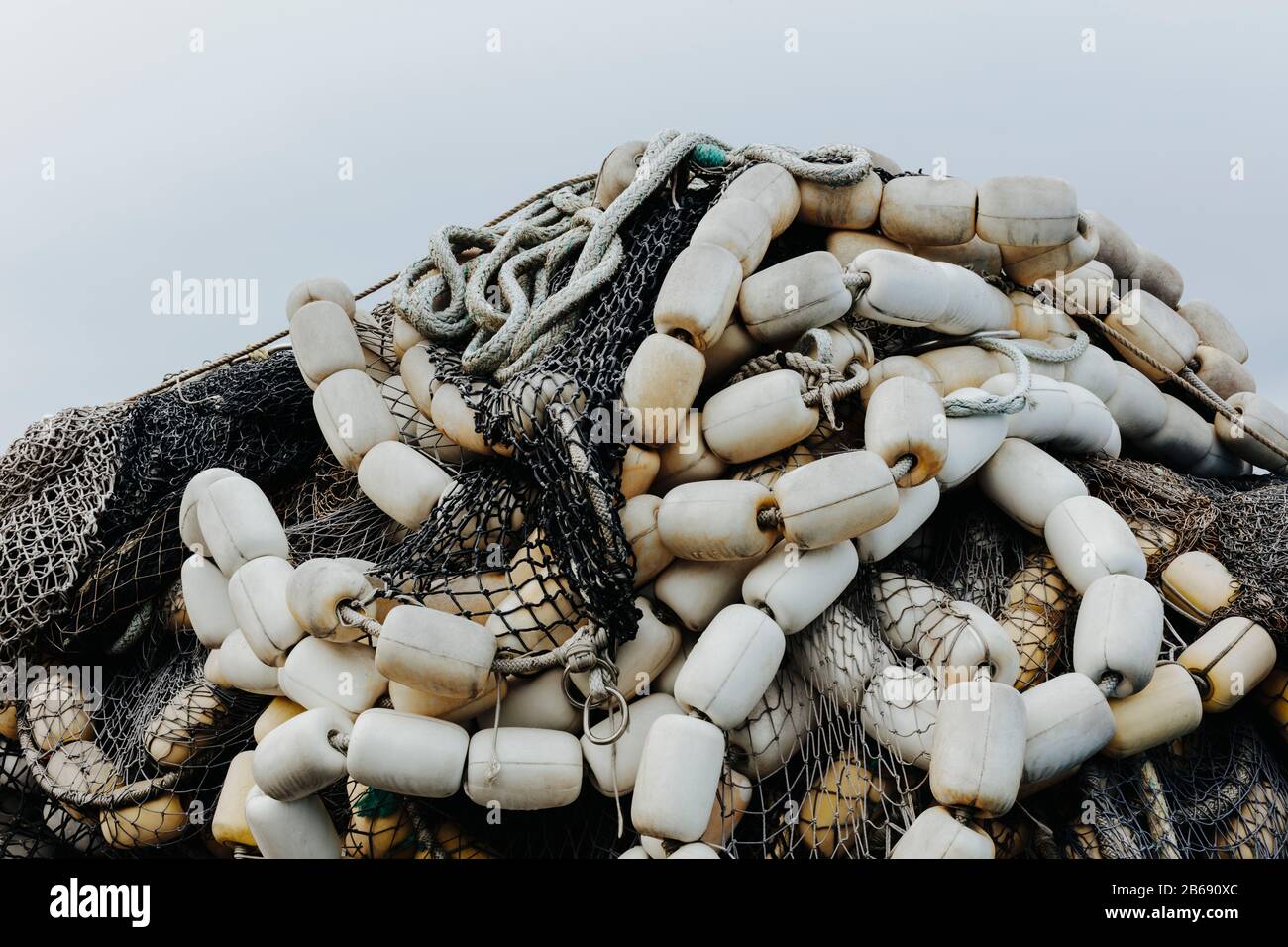 Pile of commercial fishing nets and gill nets on a fishing quay Stock