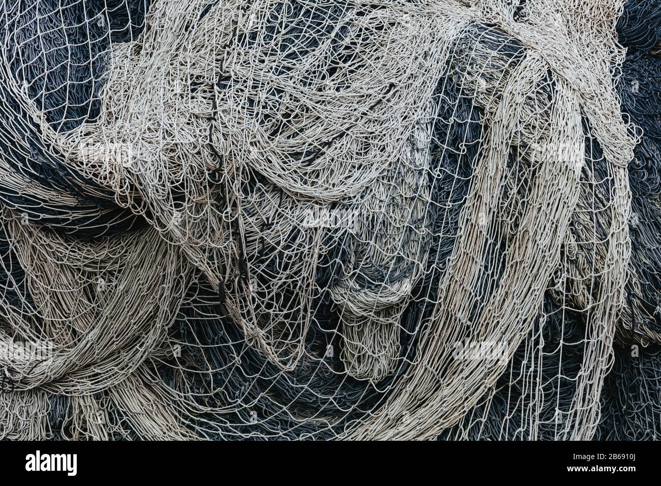 Pile of commercial fishing nets and gill nets on a fishing quay Stock