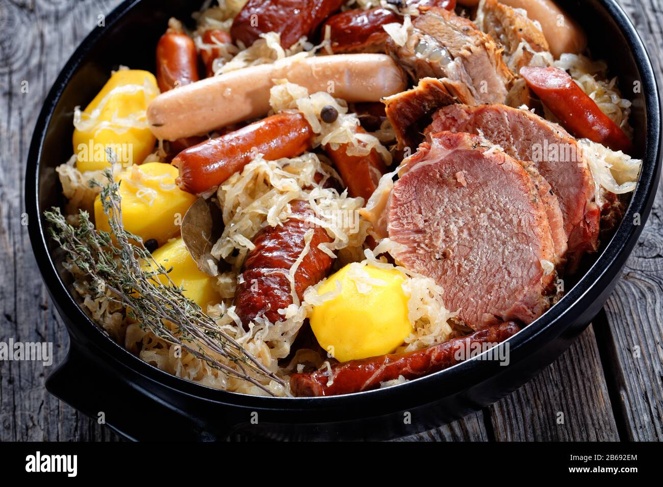 The Alsace sauerkraut, named choucroute in french a fermented cabbage stew with pork loin, bacon, and sausages: bratwurst, knockwurst cooked with pota Stock Photo