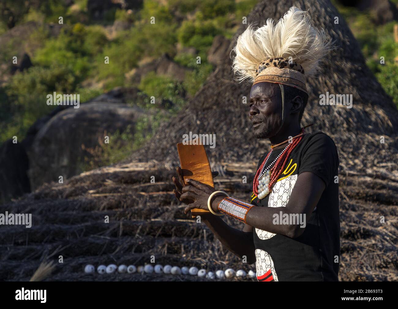 Larim tribe man with a wooden seat during a wedding ceremony, Boya Mountains, Imatong, South Sudan Stock Photo