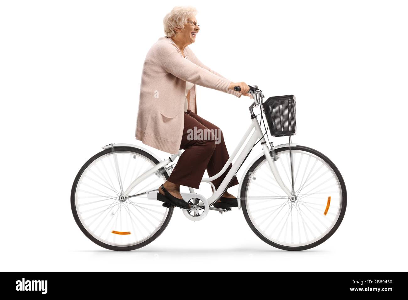 Senior woman riding a bicycle and smiling isolated on white background Stock Photo