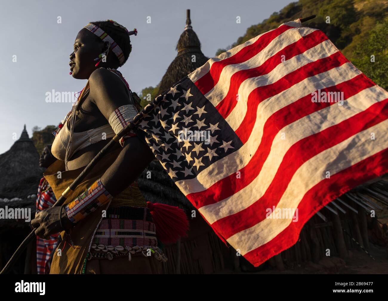 Larim tribe woman with an american flag during a wedding celebration, Boya Mountains, Imatong, South Sudan Stock Photo