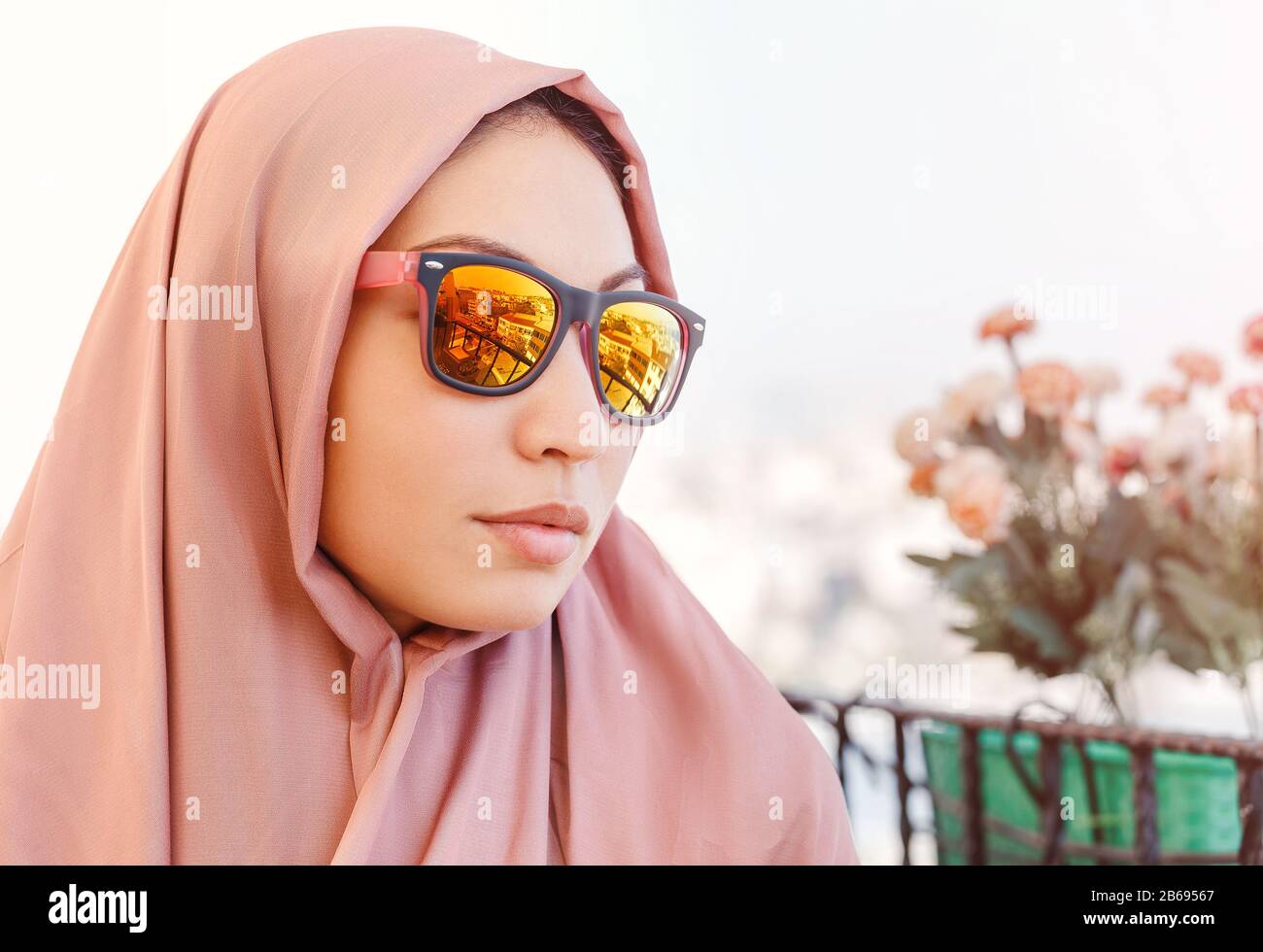 Muslim Woman wearing head scarf and sunglasses with city reflections Stock Photo