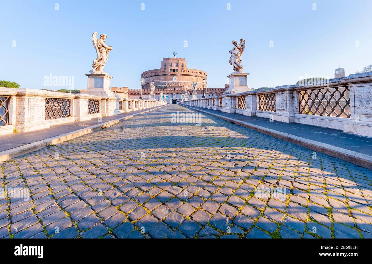 Empty cobble street across deserted bridge Ponte Sant' Angelo leading to Castel Sant' Angelo / the former Mausoleum of Hadrian in Rome Stock Photo