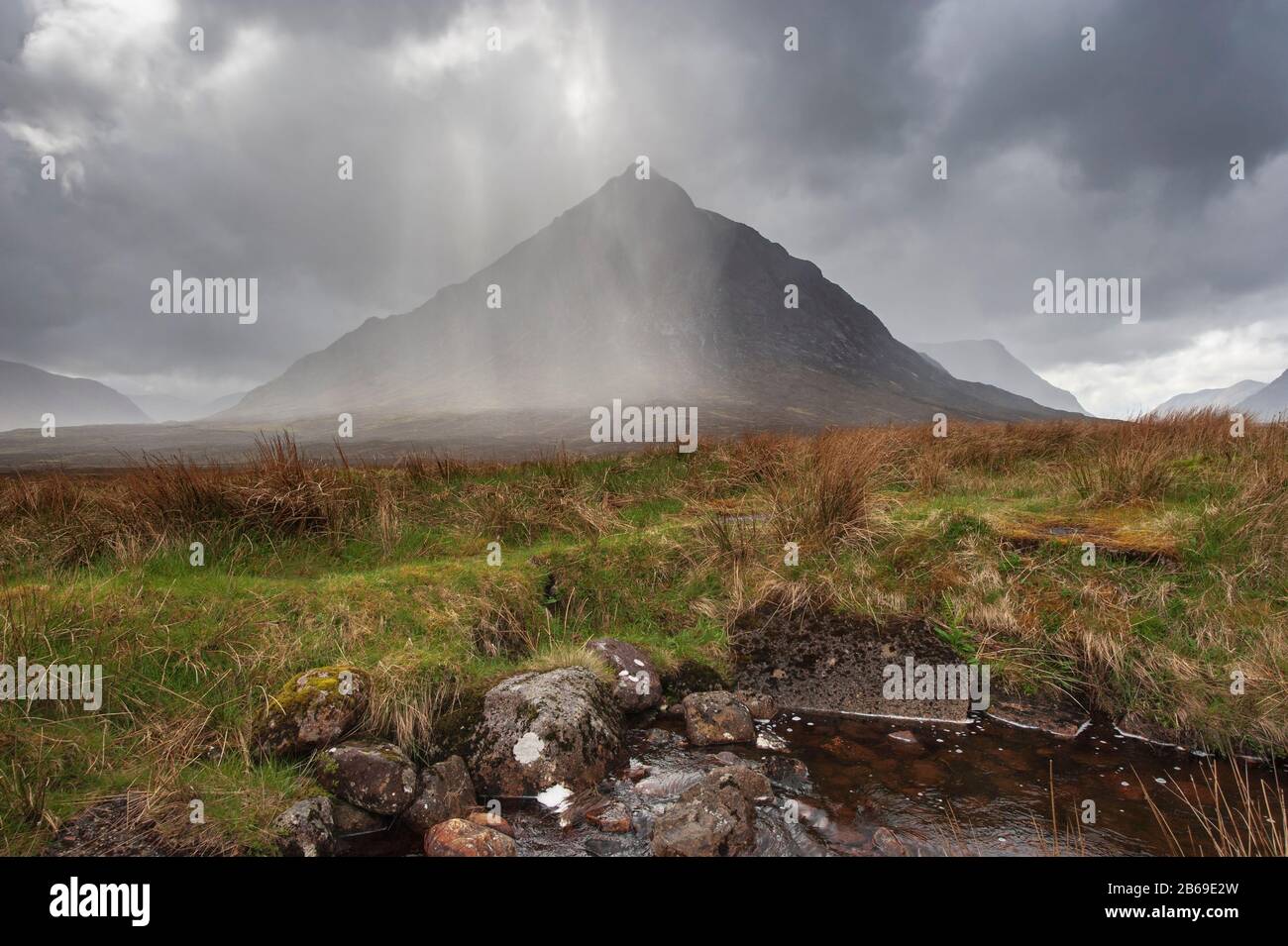 Wet stormy weather in Glen Coe in Scottish Highlands. Rain clouds sweep across Stob Dearg the northern peak of Buachaille Etive Mor Stock Photo
