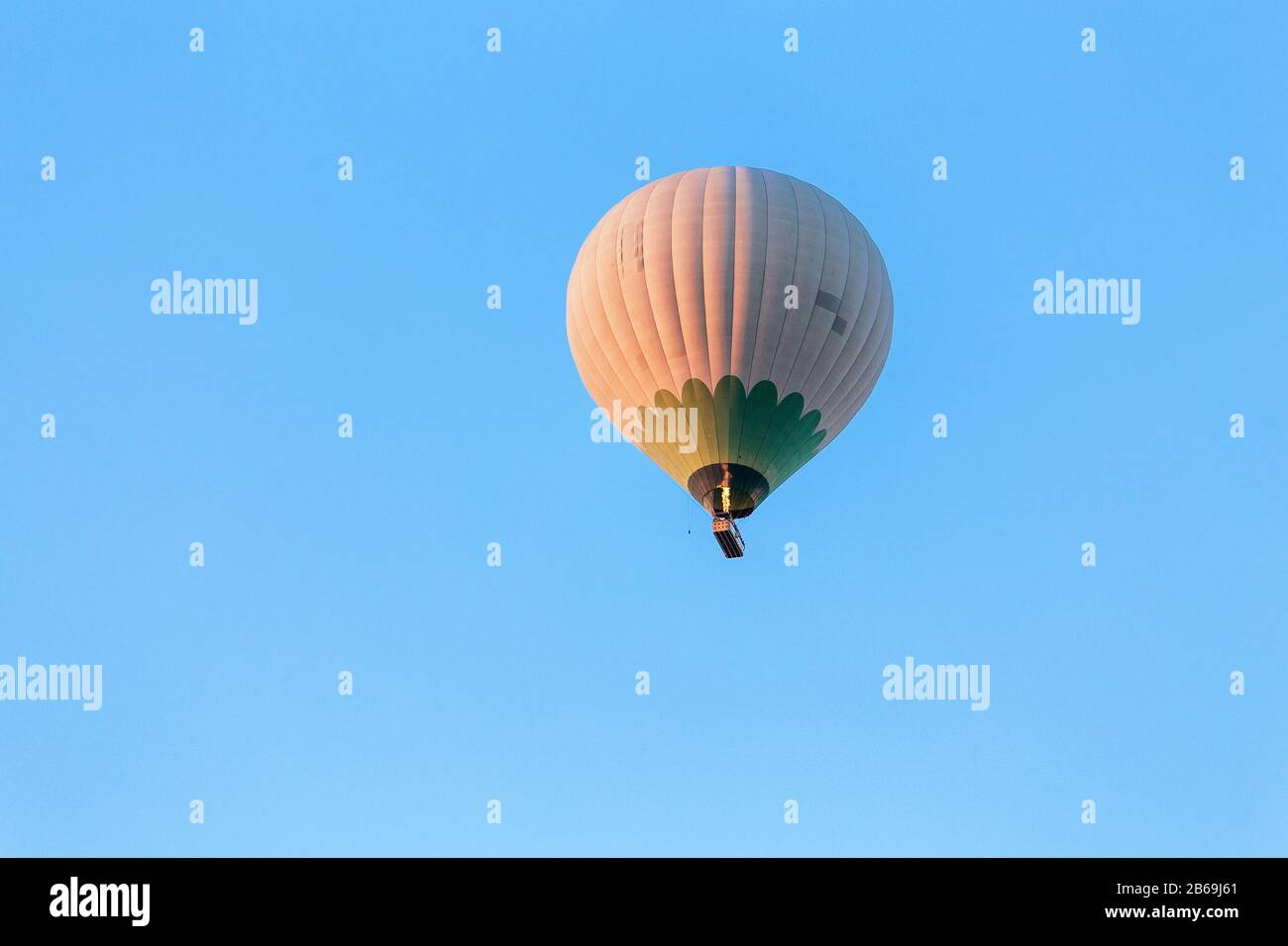 One hot air balloon flying at blue sky background at sunrise in the ...