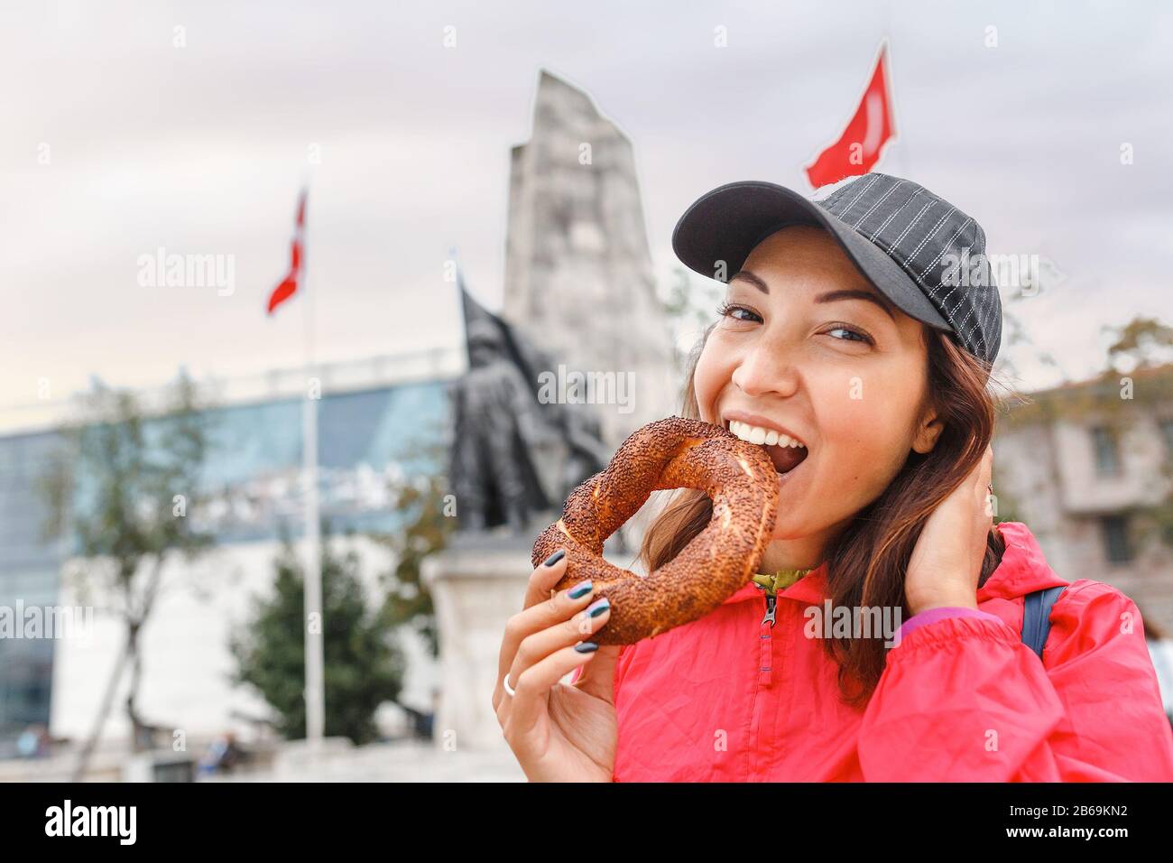 Happy woman eating traditional turkish bread bagel in Istanbul, Turkey Stock Photo