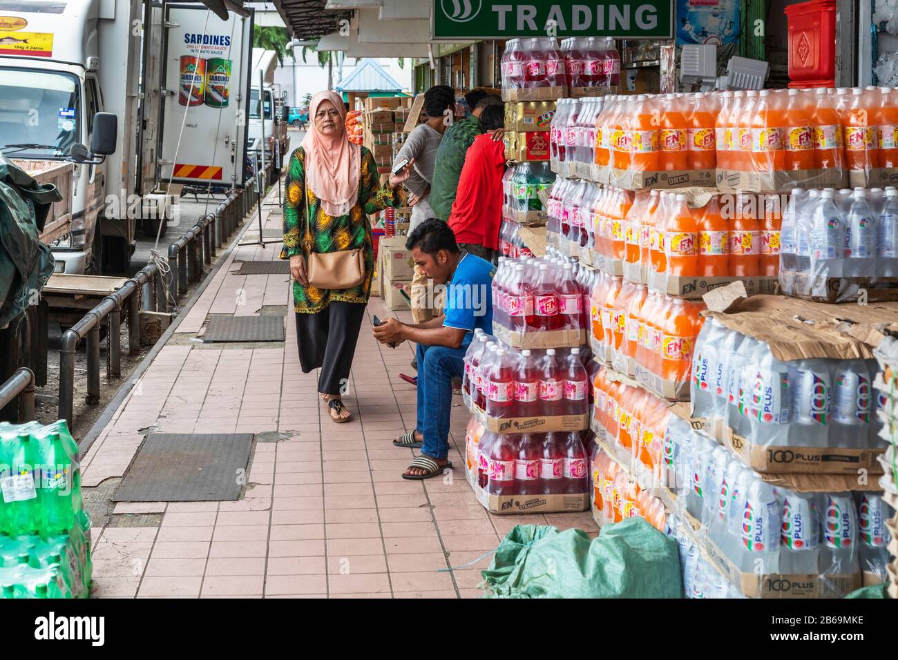 Local drinks retailer siting outside his premises at Sandakan harbour, Sabah District, Borneo, Malaysia, Asia Stock Photo