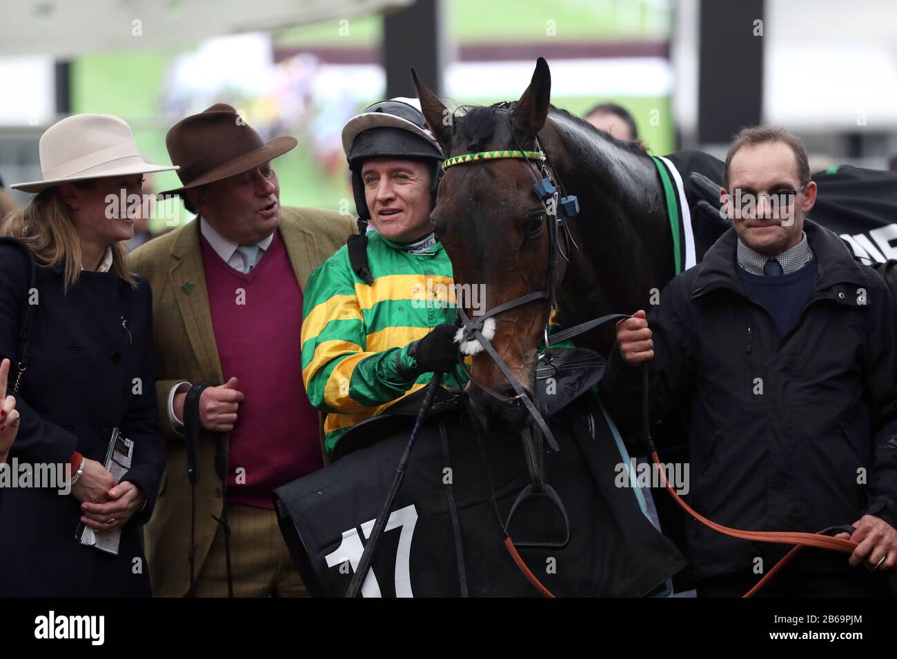 Barry Geraghty alongside Epatante and trainer Nicky Henderson following their victory in the Unibet Champion Hurdle Challenge Trophy on day one of the Cheltenham Festival at Cheltenham Racecourse, Cheltenham. Stock Photo